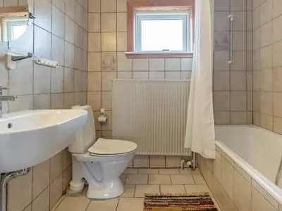 a bathroom with a toilet and a sink and a tub at 4 person holiday home in Frøstrup in Frøstrup