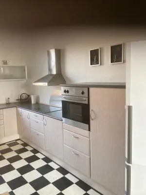 a kitchen with a stove and a checkered floor at Store Sand in Vemb