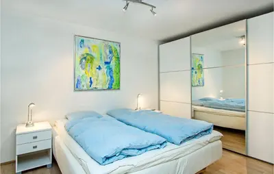 a bedroom with a bed with blue sheets and a mirror at Lovely Home In Thisted With Kitchen in Thisted