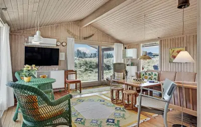 a living room with a table and a couch at Beautiful Home In Løkken With Wifi in Løkken
