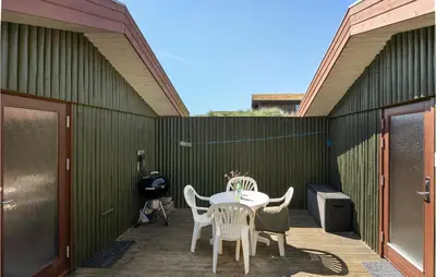 a patio with a table and chairs and a fence at Beautiful Home In Løkken With Wifi in Løkken