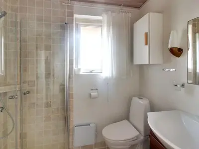a bathroom with a toilet and a shower and a sink at Holiday Home Ågot - 75m from the sea by Interhome in Torsted