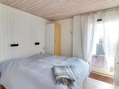 a bed in a room with a large window at Holiday Home Ågot - 75m from the sea by Interhome in Torsted