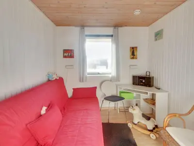 a living room with a red couch and a desk at Holiday Home Ågot - 75m from the sea by Interhome in Torsted