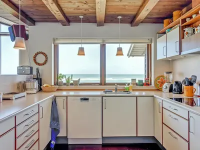 a kitchen with white cabinets and a large window at Holiday Home Arngrim - 100m from the sea by Interhome in Torsted