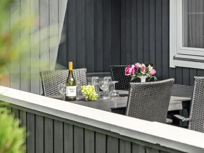 a table with a bottle of wine on a patio at Holiday Home Siri - 400m from the sea by Interhome in Thisted