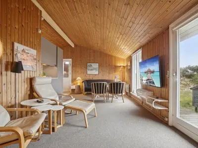 a living room with wooden walls and a large window at Holiday Home Siri - 400m from the sea by Interhome in Thisted