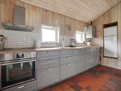 a kitchen with white appliances and wooden walls at Holiday Home Gottliebe - 850m from the sea by Interhome in Torsted