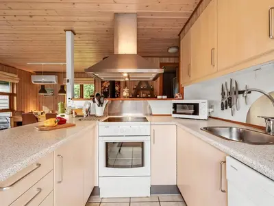 a kitchen with white cabinets and a sink and a stove at Holiday Home Engeline - 300m to the fjord by Interhome in Vemb