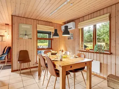 a dining room with a wooden table and chairs at Holiday Home Engeline - 300m to the fjord by Interhome in Vemb