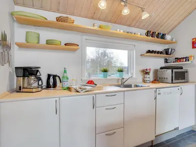 a kitchen with white cabinets and a sink and a window at Holiday Home Daina - 400m to the fjord by Interhome in Vemb