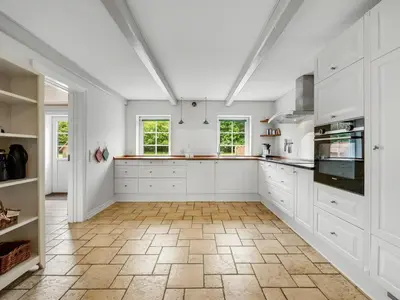 a kitchen with white cabinets and a tile floor at Holiday Home Wilmar - 1km to the fjord by Interhome in Vemb