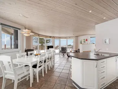a kitchen and dining room with a white table and chairs at Holiday Home Ginny - 300m to the fjord by Interhome in Struer
