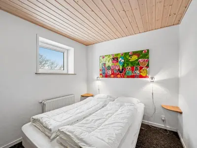 a bedroom with a bed and a painting on the wall at Holiday Home Ginny - 300m to the fjord by Interhome in Struer