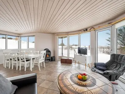 a living room with a table and some chairs at Holiday Home Ginny - 300m to the fjord by Interhome in Struer