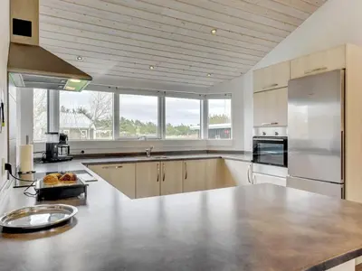 a large kitchen with stainless steel appliances and windows at Holiday Home Nani - 900m from the sea by Interhome in Torsted