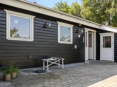 a black house with a table in front of it at Holiday Home Kai - 500m to the fjord by Interhome in Struer