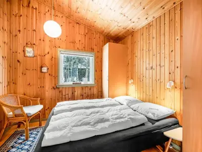 a bedroom with a bed in a wooden wall at Holiday Home Kai - 500m to the fjord by Interhome in Struer
