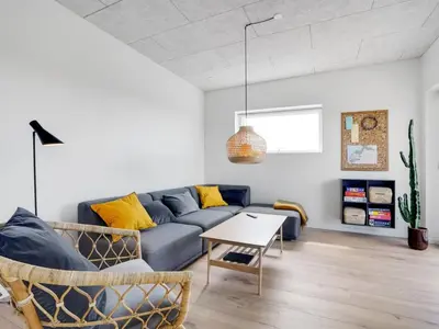 a living room with a blue couch and a table at Holiday Home Trpana - 1-6km from the sea by Interhome in Thisted