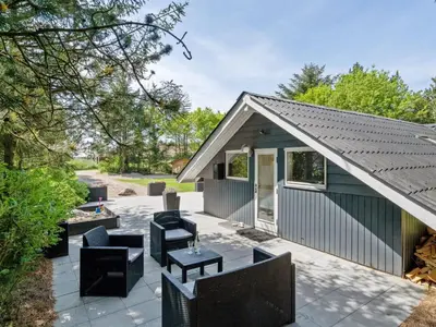 a patio with chairs and tables and a building at Holiday Home Hjalmara - 900m from the sea by Interhome in Thisted