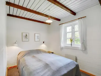 a white bedroom with a bed and a window at Holiday Home Minja - 900m from the sea by Interhome in Thisted