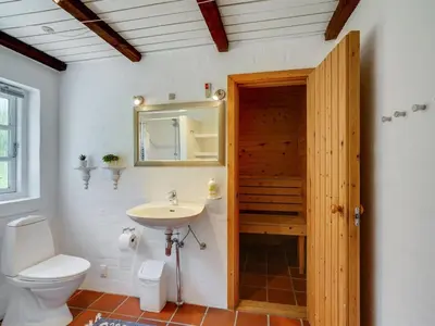a bathroom with a toilet and a sink and a mirror at Holiday Home Minja - 900m from the sea by Interhome in Thisted