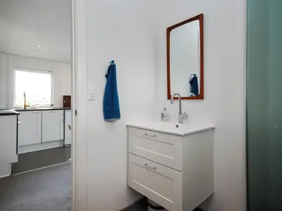 a white bathroom with a sink and a mirror at Holiday Home Engelbertine - 900m from the sea by Interhome in Thisted
