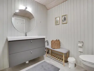 a bathroom with a sink and a mirror and a toilet at Holiday Home Bente - 800m from the sea by Interhome in Thisted