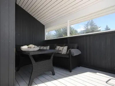 a porch with a table and chairs and a window at Holiday Home Bente - 800m from the sea by Interhome in Thisted