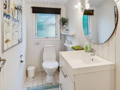 a bathroom with a toilet and a sink and a mirror at Holiday Home Emeline - 1-7km from the sea by Interhome in Thisted