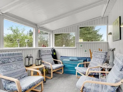 a screened in porch with chairs and a table at Holiday Home Gundina - 2km from the sea by Interhome in Thisted