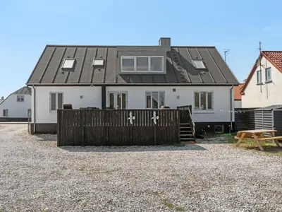 a white house with a black roof and a wooden fence at Holiday Home Thilla - 100m from the sea by Interhome in Thisted