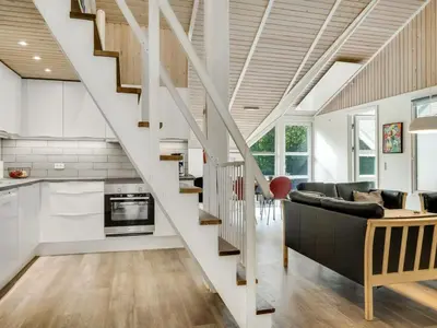 a living room with a couch and a staircase at Holiday Home Eisa - 300m to the fjord by Interhome in Øsløs