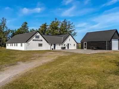 a large white barn with a black roof at Holiday Home Elisa - 1-2km from the sea by Interhome in Bedsted Thy