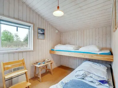 a room with two bunk beds and a window at Holiday Home Aameek - 3km from the sea by Interhome in Frøstrup