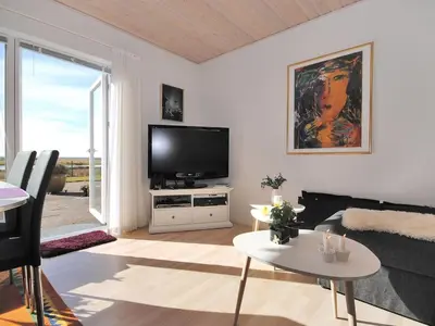 a living room with a television and a table at Apartment Rejhana - 500m to the fjord by Interhome in Øsløs