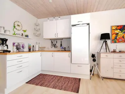 a kitchen with white cabinets and a refrigerator at Apartment Rejhana - 500m to the fjord by Interhome in Øsløs