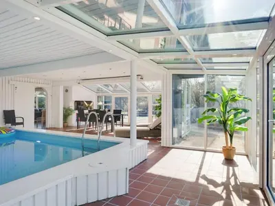 an indoor pool in a house with a glass ceiling at Holiday Home Gertrudis - 2km to the fjord by Interhome in Frøstrup