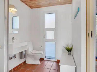 a bathroom with a toilet and a sink at Holiday Home Gertrudis - 2km to the fjord by Interhome in Frøstrup