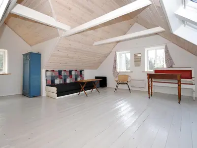 a living room with a piano and a table at Holiday Home Margrethe - 1-1km from the sea by Interhome in Bedsted Thy