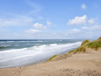 a sandy beach with the ocean in the background at Holiday Home Margrethe - 1-1km from the sea by Interhome in Bedsted Thy