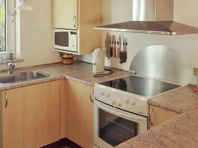 a kitchen with a stove top oven next to a sink at Holiday Home Simo - 250m from the sea by Interhome in Øsløs