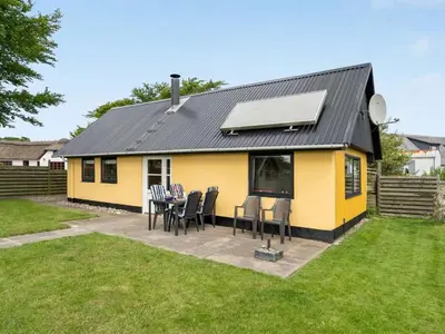 a yellow and black house with a table and chairs at Holiday Home Leocadia - 150m to the fjord by Interhome in Øsløs