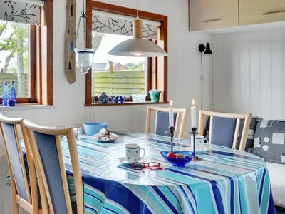 a dining room table with a blue and white table cloth at Holiday Home Leocadia - 150m to the fjord by Interhome in Øsløs