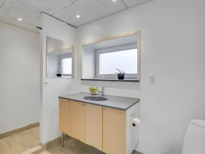 a bathroom with a sink and two windows at Holiday Home Markhild - 300m to the fjord by Interhome in Sønder Ydby