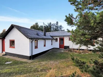 a white house with a red door and a yard at Holiday Home Palle - 2km from the sea by Interhome in Snedsted