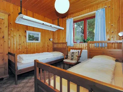two beds in a room with wooden walls at Holiday Home Palle - 2km from the sea by Interhome in Snedsted