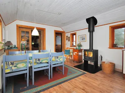 a dining room with a fireplace and a table and chairs at Holiday Home Palle - 2km from the sea by Interhome in Snedsted