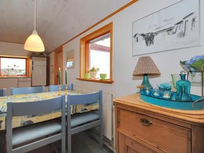 a dining room with a table and blue chairs at Holiday Home Palle - 2km from the sea by Interhome in Snedsted