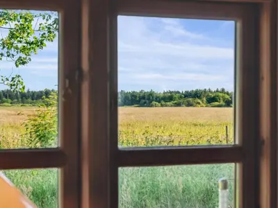 an open window looking out at a field of grass at Holiday Home Elsia - 1-5km to the fjord by Interhome in Frøstrup